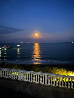 a view of the ocean at night with a fence at Azzurro Premium Apartment on Bulevard Bogoridi in Burgas City