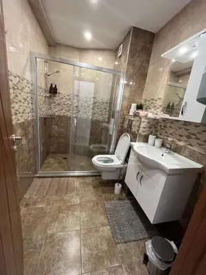 a bathroom with a shower and a toilet and a sink at Azzurro Premium Apartment on Bulevard Bogoridi in Burgas City