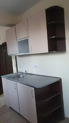 a kitchen with a sink and white cabinets at Viriks in Burgas City