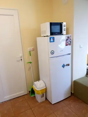 a white refrigerator with a microwave on top of it at Viriks in Burgas City