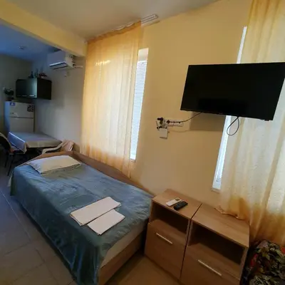a small bedroom with a bed and a flat screen tv at Viriks in Burgas City