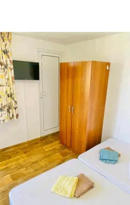 a bedroom with a bed and a wooden cabinet at Krimski Guest House and Bungalows in Byala