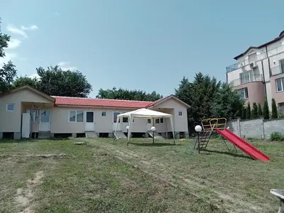 a playground with a red slide in a yard at Krimski Guest House and Bungalows in Byala