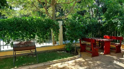 a table and chairs sitting under a tree at Summer Dreams - Menada Apartments in Sunny Beach
