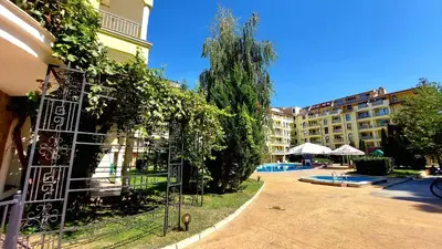 a view of a courtyard with a building and a tree at Summer Dreams - Menada Apartments in Sunny Beach