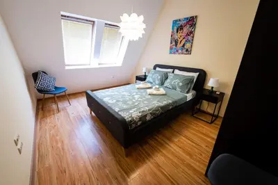 a bedroom with a bed and a chandelier at При Галя / Прекрасен апартамент в тих квартал in Varna City