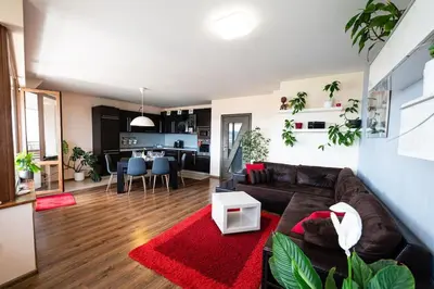 a living room with a brown couch and a red rug at При Галя / Прекрасен апартамент в тих квартал in Varna City