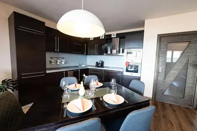 a kitchen with a dining room table with chairs at При Галя / Прекрасен апартамент в тих квартал in Varna City