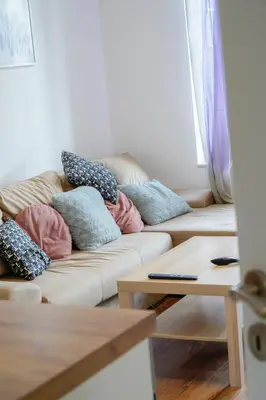 a living room with a couch with pillows on it at Central Cosy, Fully Renovated 2BD Near the Cathedral in Varna City