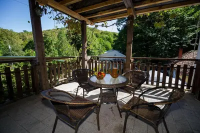 a patio with a table and chairs on a porch at Рибарник Forest Мagic in Topolitsa