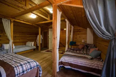 a bedroom with two beds in a log cabin at Рибарник Forest Мagic in Topolitsa