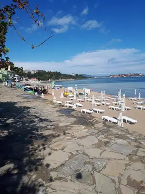 a row of white chairs on a beach at Evridika Apartments in Nesebar