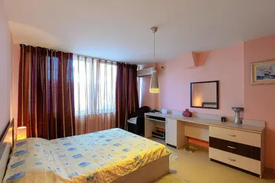 a bedroom with a bed and a desk and a deskablish at Evridika Apartments in Nesebar