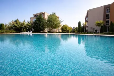a large swimming pool with blue water in a building at Nice family apartment in Sunny Beach