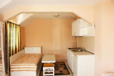 a small room with a bed and a sink at Family Hotel Paros 2 in Pomorie