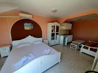 a bedroom with a large white bed with towels on it at Family Hotel Paros 2 in Pomorie
