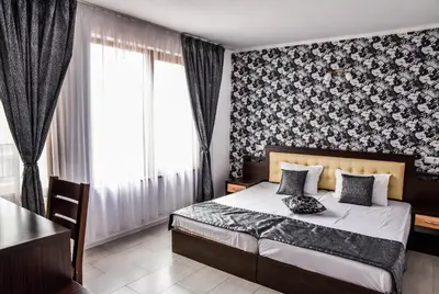 a bedroom with a bed and a table and a window at Dimitur Jekov Guest House in Obzor