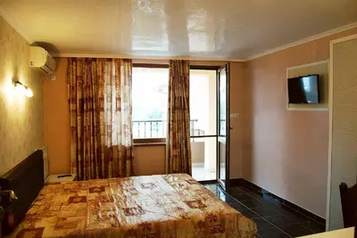 a bedroom with a large bed and a window at Dimitur Jekov Guest House in Obzor