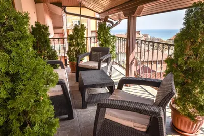 a balcony with wicker chairs and a view of the ocean at Dimitur Jekov Guest House in Obzor