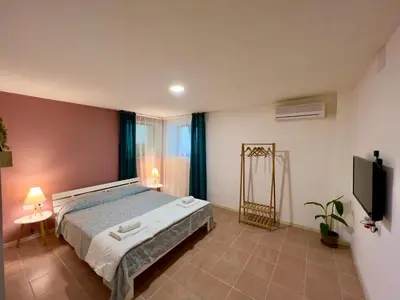 a bedroom with a bed and a flat screen tv at Vi Del Mar Apartments Varna in Varna City