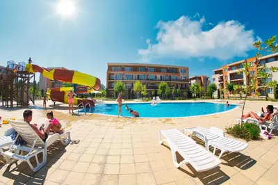a group of people sitting in lawn chairs by a pool at Nessebar and Holiday Fort Apartments in Sunny Beach