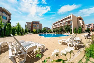 a patio with lounge chairs and a swimming pool at Nessebar and Holiday Fort Apartments in Sunny Beach