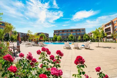 a courtyard with flowers and a swimming pool at Nessebar and Holiday Fort Apartments in Sunny Beach