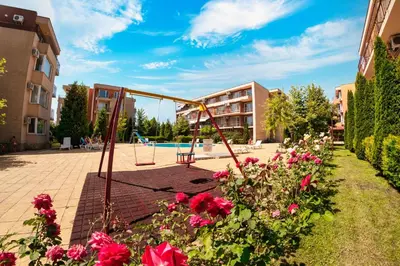 a playground with flowers in front of a building at Nessebar and Holiday Fort Apartments in Sunny Beach