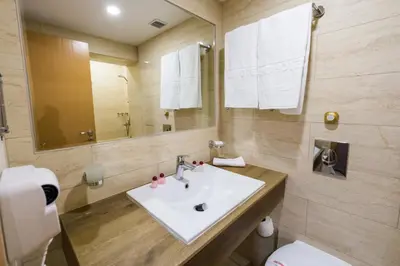 a bathroom with a sink and a toilet and a mirror at Grand Hotel Sunny Beach - All Inclusive in Sunny Beach