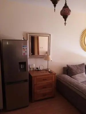 a kitchen with a refrigerator and a table with a lamp at Liliya in Sveti Vlas