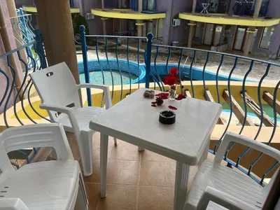 a white table and chairs next to a swimming pool at Camping Gradina Garden Beach b33 in Chernomorets