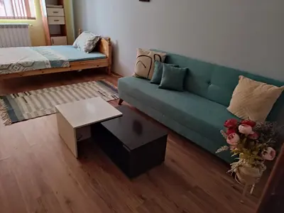 a living room with a green couch and a table at Стая за гости на гр.Бургас in Burgas City