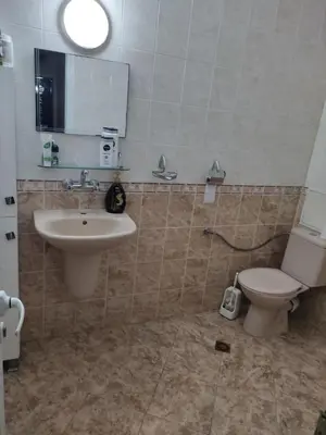 a bathroom with a sink and a toilet and a mirror at Стая за гости на гр.Бургас in Burgas City