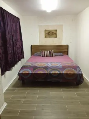 a bedroom with a bed with a purple comforter at Апартаменти Стефанов in Varna City