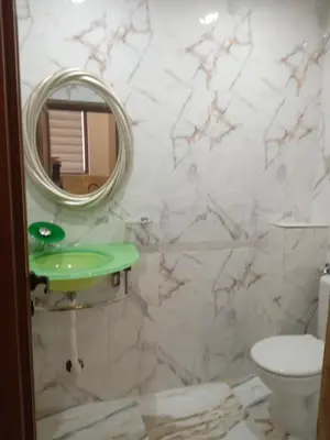 a bathroom with a green sink and a mirror at Апартаменти Стефанов in Varna City