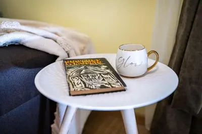 a book on a table next to a coffee mug at Sunny and Quiet 2bdr Central Apartment in Varna City