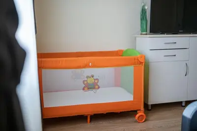 a small crib with a toy in a bedroom at Sunny and Quiet 2bdr Central Apartment in Varna City