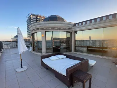a bed on top of a balcony with a building at Penthouse Happy Moments in Sunny Beach