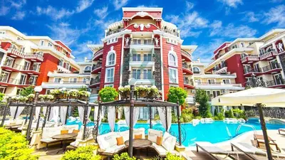 a hotel with a pool in front of a building at Messembria Resort in Sunny Beach
