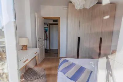 a bedroom with a bed and a dresser with a lamp at Messembria Resort in Sunny Beach