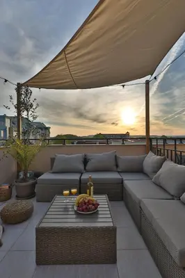 a patio with a couch and a table with a bowl of fruit at Messembria Resort in Sunny Beach