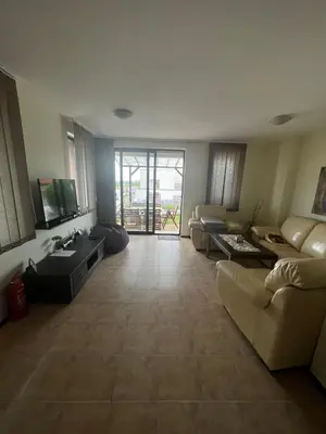 a living room with a couch and a tv at Велика Гардън - Акация 6 in Lozenets