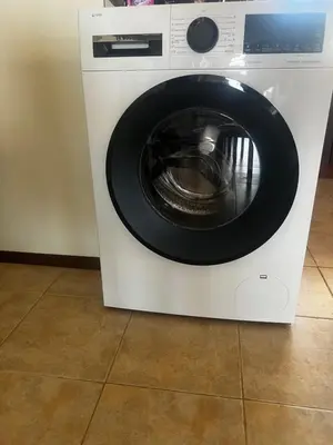 a white washing machine with a black door at Велика Гардън - Акация 6 in Lozenets