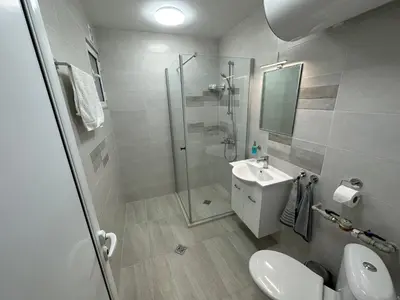 a bathroom with a shower and a toilet and a sink at Апартамент Опера. Стил и комфорт. Идеален център. in Varna City