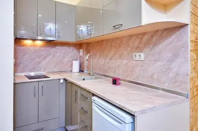 a kitchen with marble counter tops and white appliances at Къща за гости КИТАНОВ in Pomorie