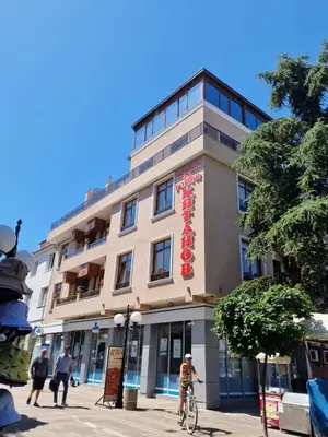 a man riding a bike in front of a building at Къща за гости КИТАНОВ in Pomorie