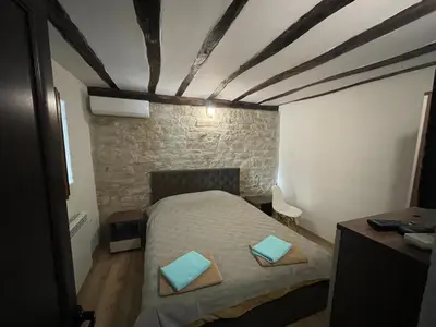 a bedroom with a bed with blue pillows on it at DeTY’s Guest House in Drachevo