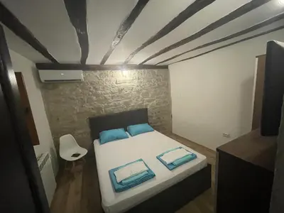a bedroom with a bed with blue pillows on it at DeTY’s Guest House in Drachevo