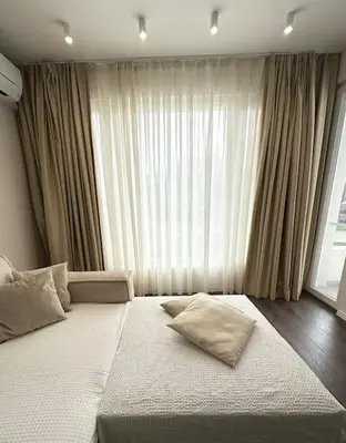 a large bed in a bedroom with a large window at New luxury furnished apartment - beach, Varna center & fast Wi-FI in Varna City