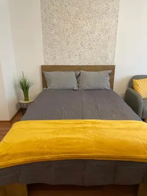 a bed with a yellow blanket on top of it at Sity Home in Burgas City